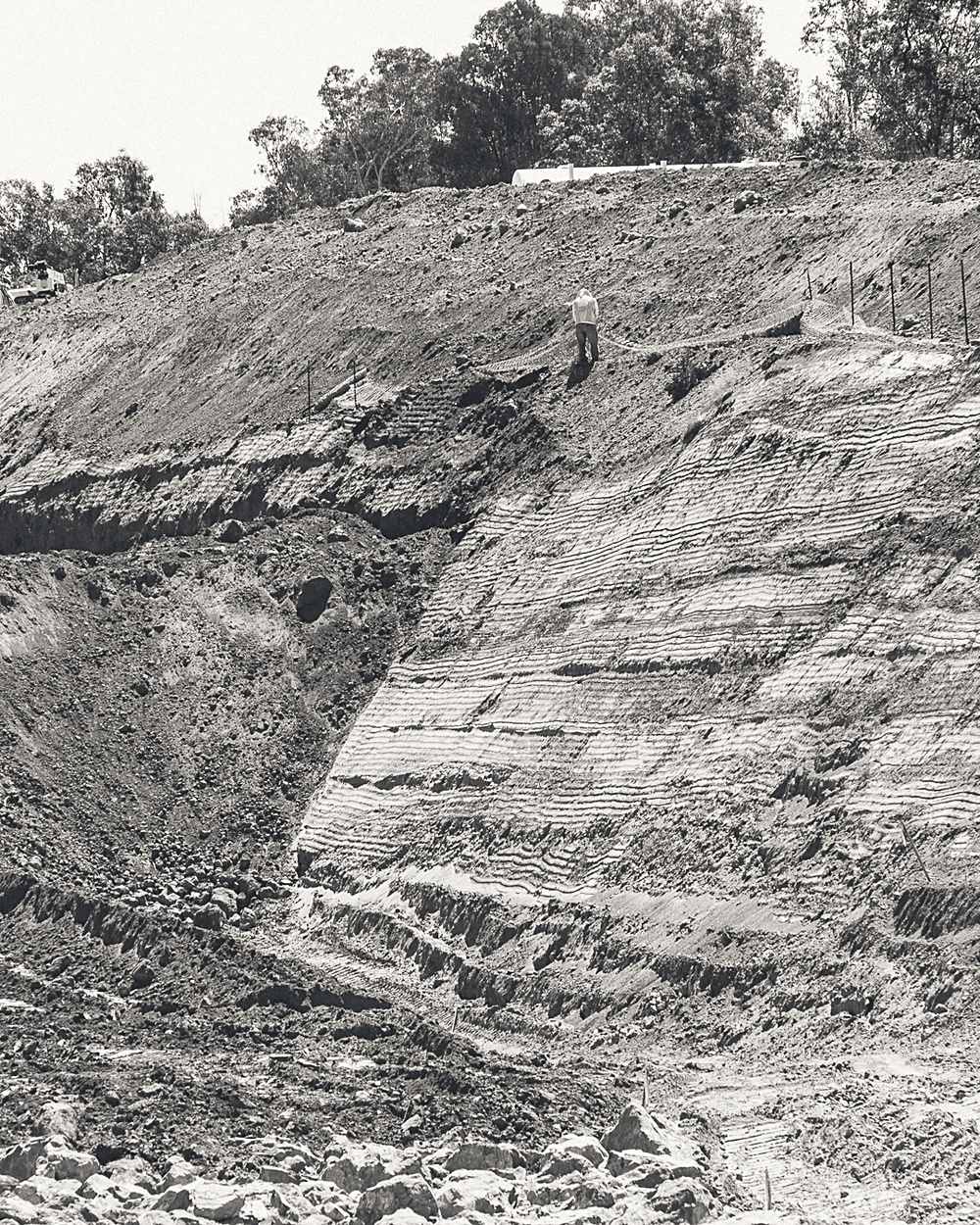Steep cut slope exposing bedded strata